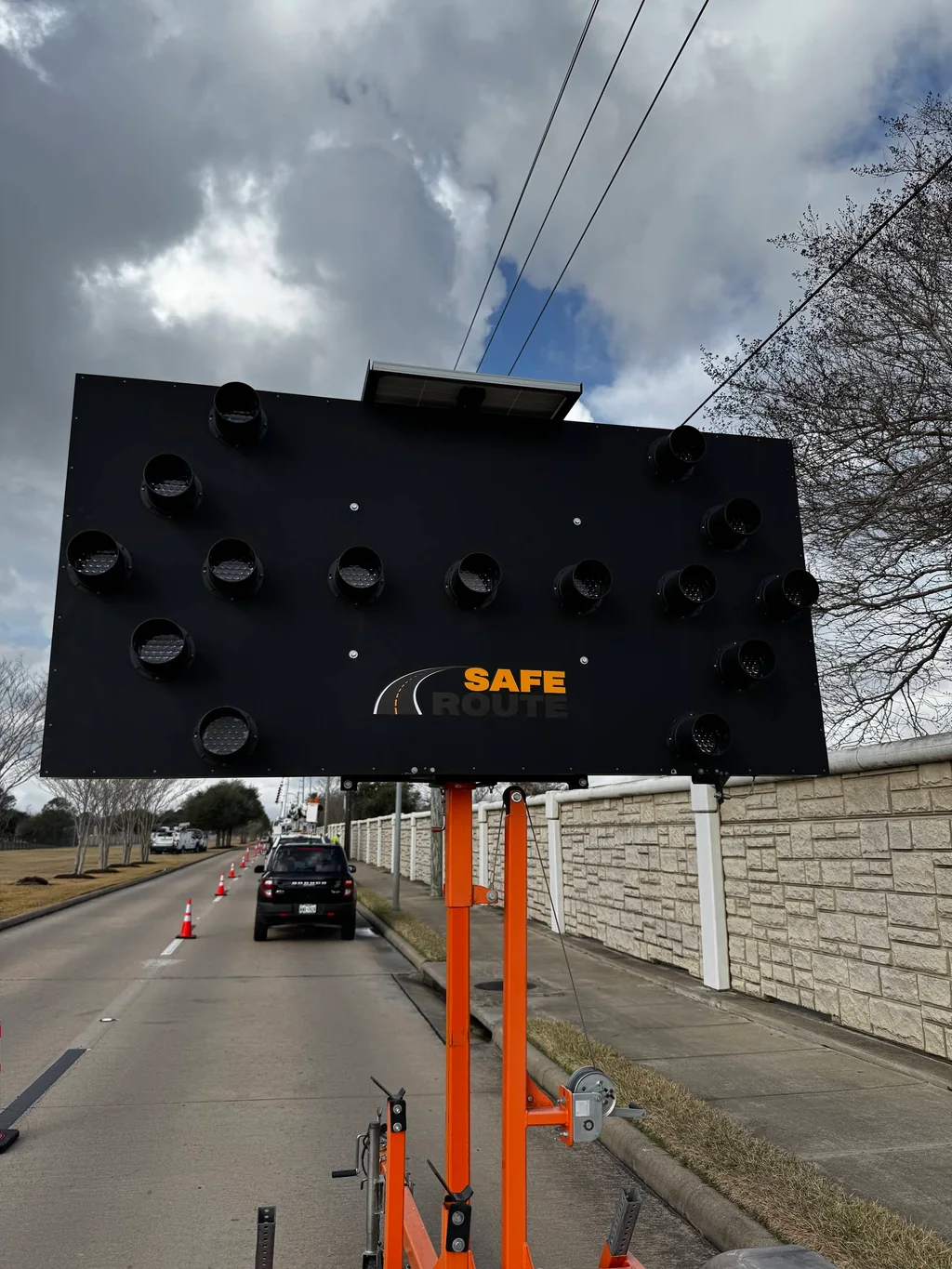 Portable Safe Route arrow board beside a coned street work area.