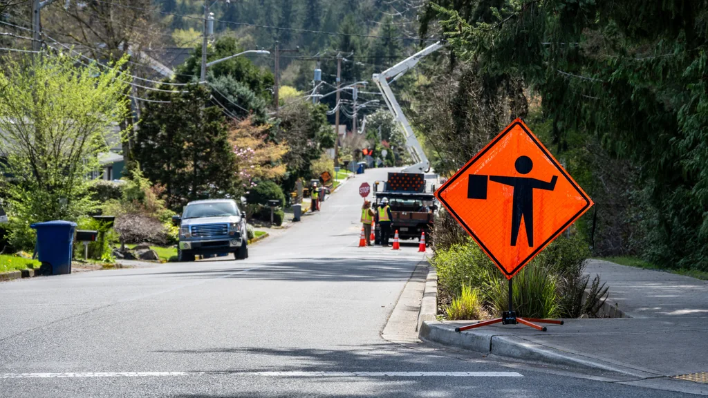 Bucket truck with a Flagger Ahead sign.