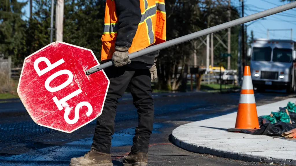 Flagger holding a STOP/SLOW paddle.